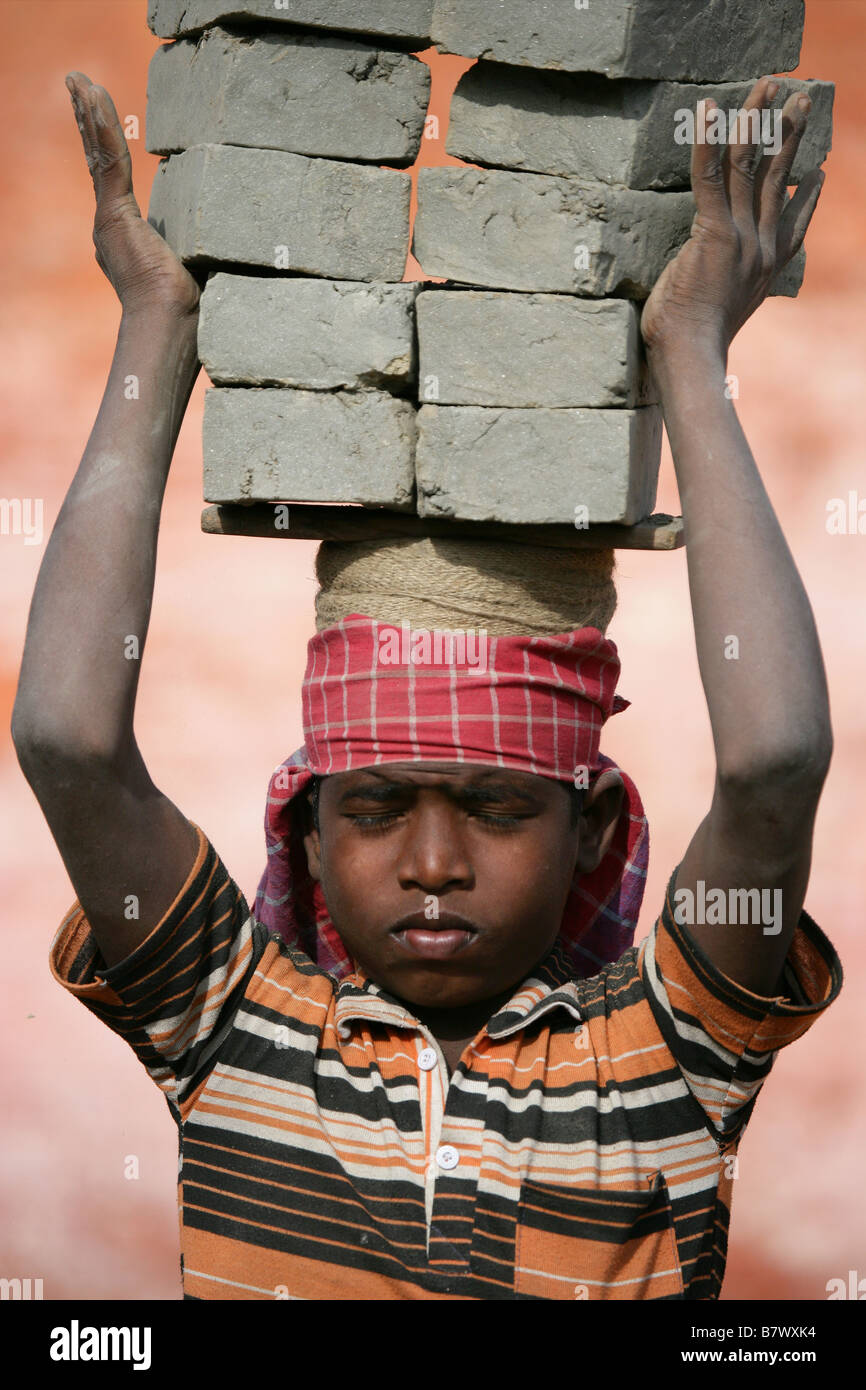 Eleven year old Indian boy carrying hand made bricks Nepalese brick
