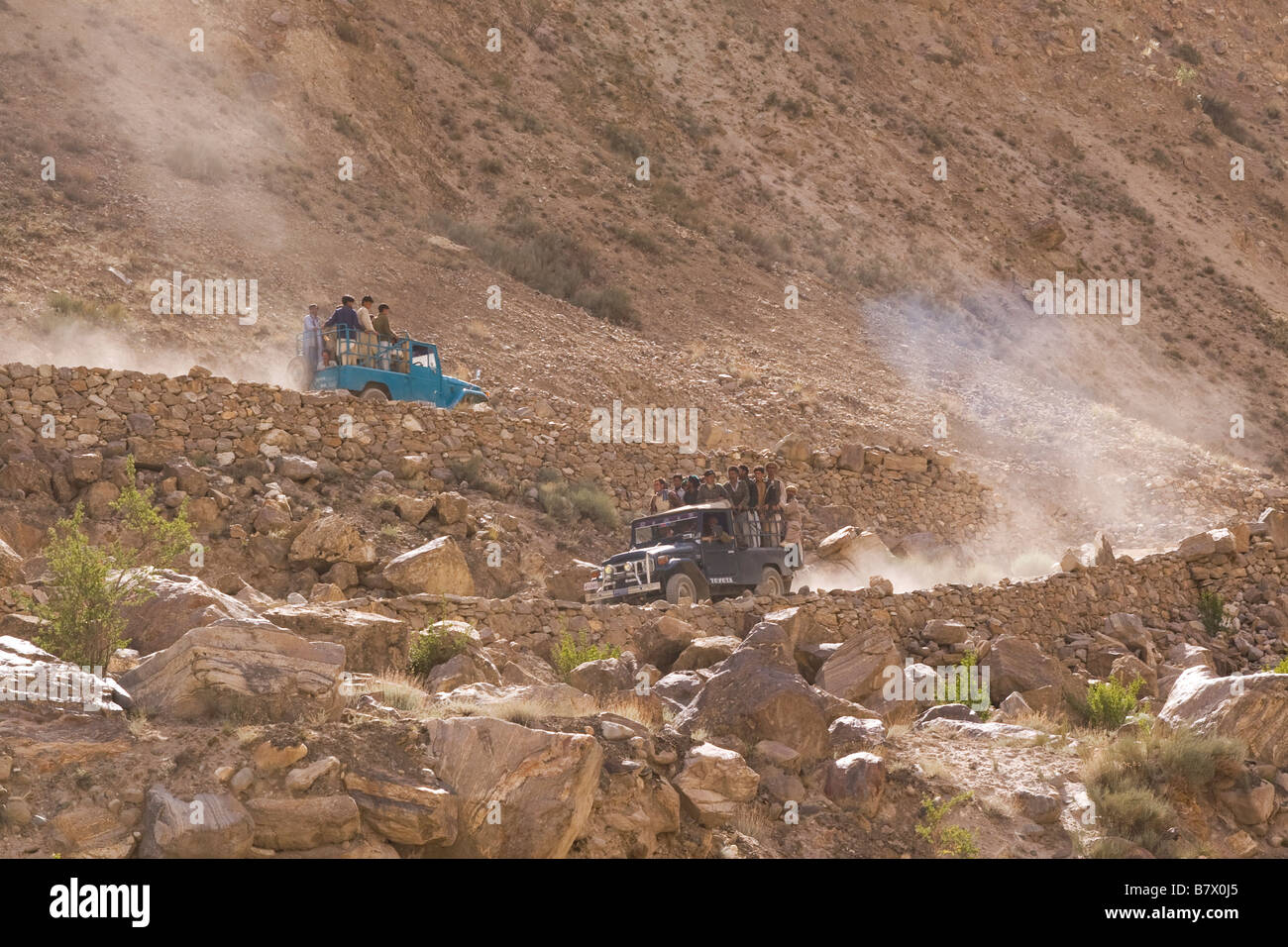 Balti porters riding in jeeps on the dusty road to Askole in Baltistan in Pakistan Stock Photo