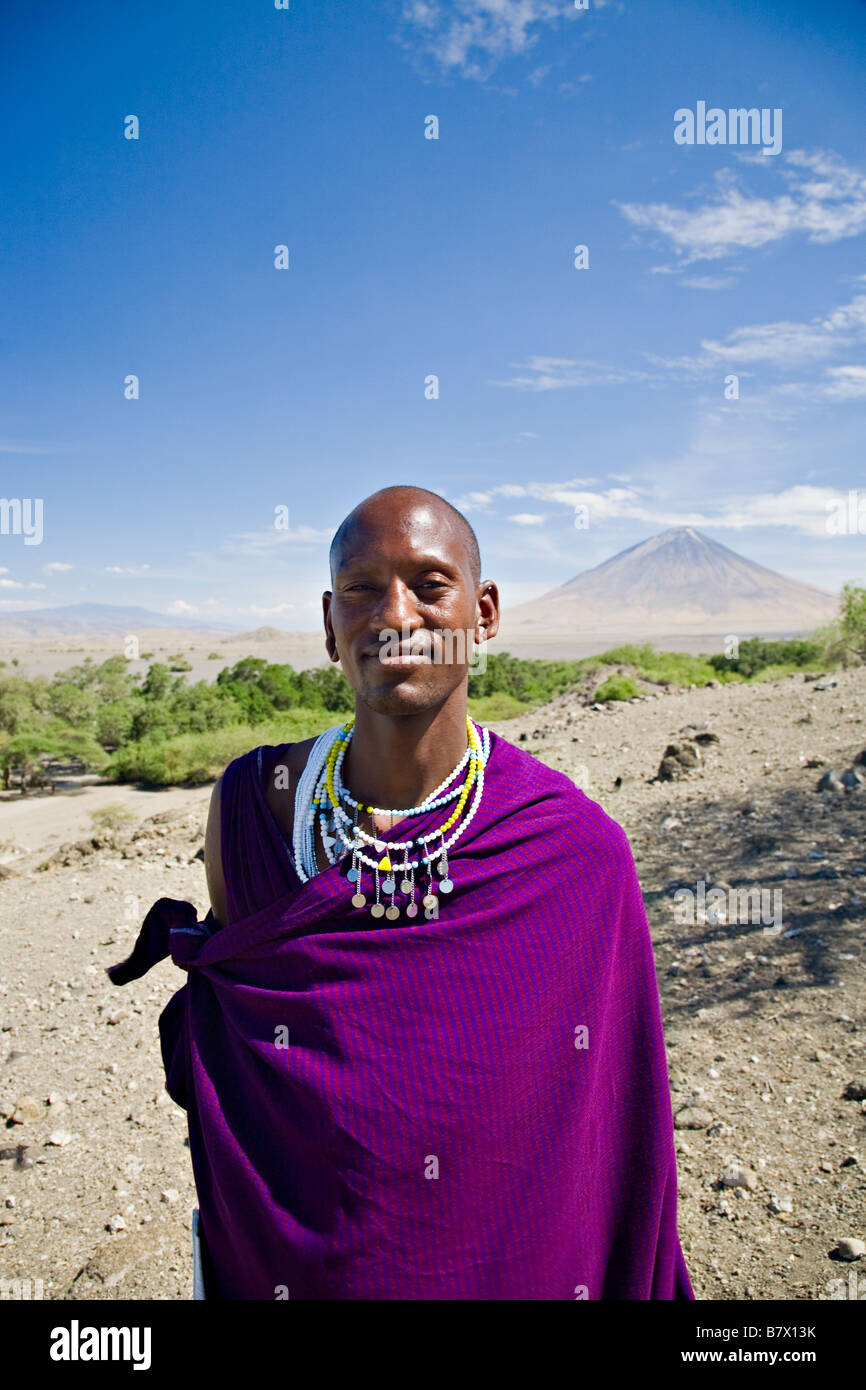 Masai man, Ol' Donyo Lengai volcano visible in a distance, Tanzania, Africa Stock Photo