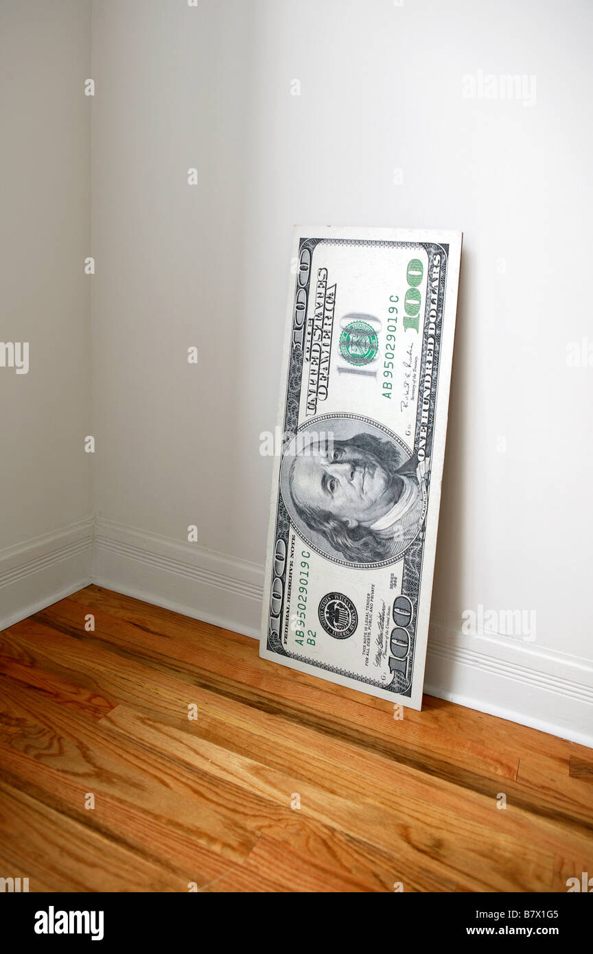 Oversized 100 dollar bill leaning against wall Stock Photo