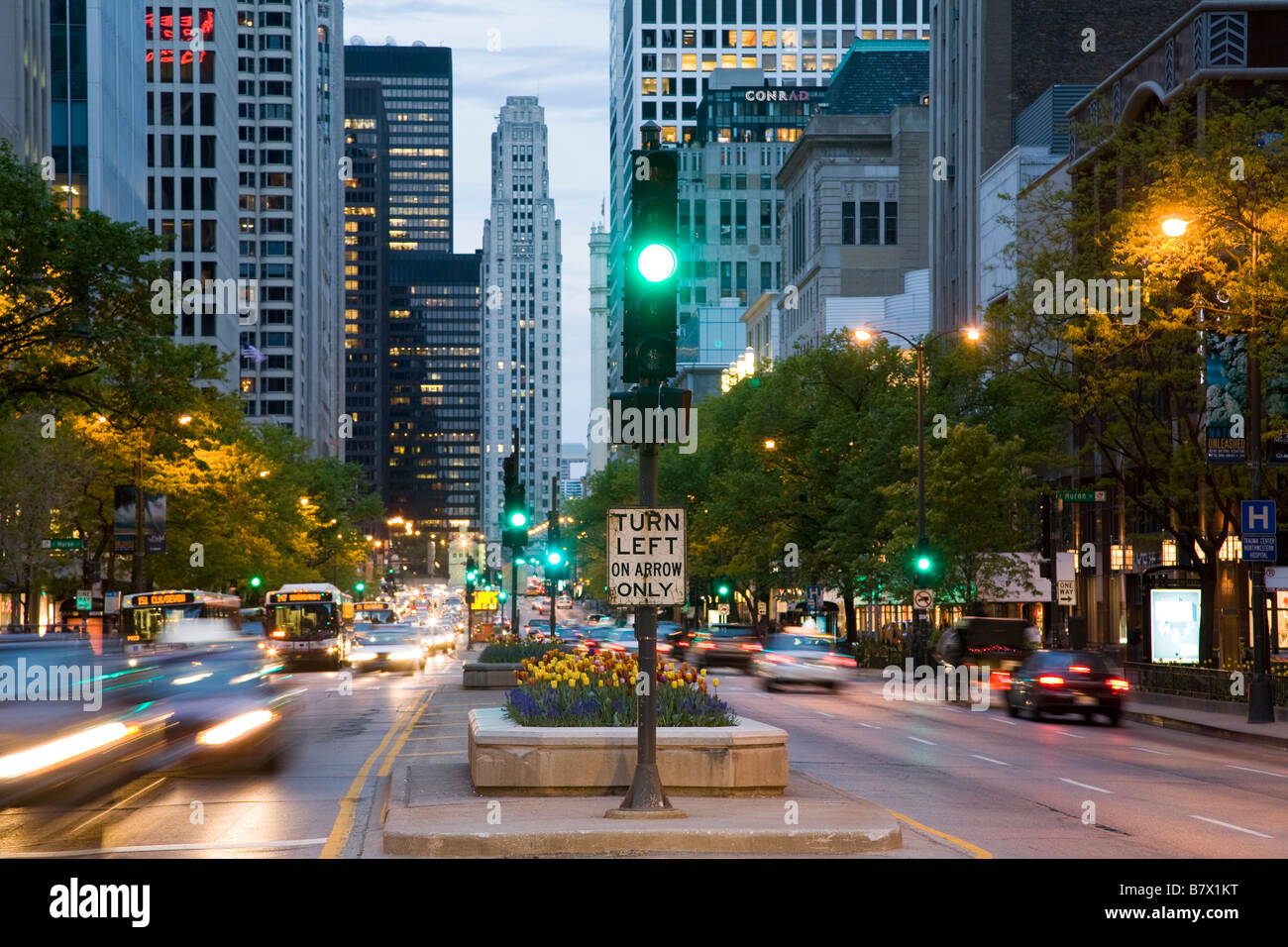 ILLINOIS Chicago Traffic signal in median of Michigan Avenue at dusk blur of cars passing left turn on arrow sign Stock Photo