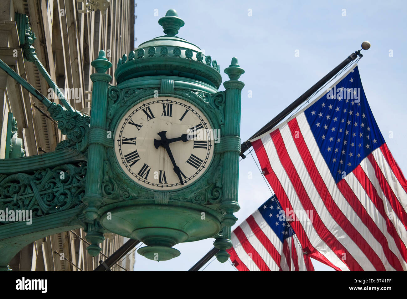 ILLINOIS Chicago Famous Marshall Fields clock and American flags on exterior of Macys State Street department store Stock Photo