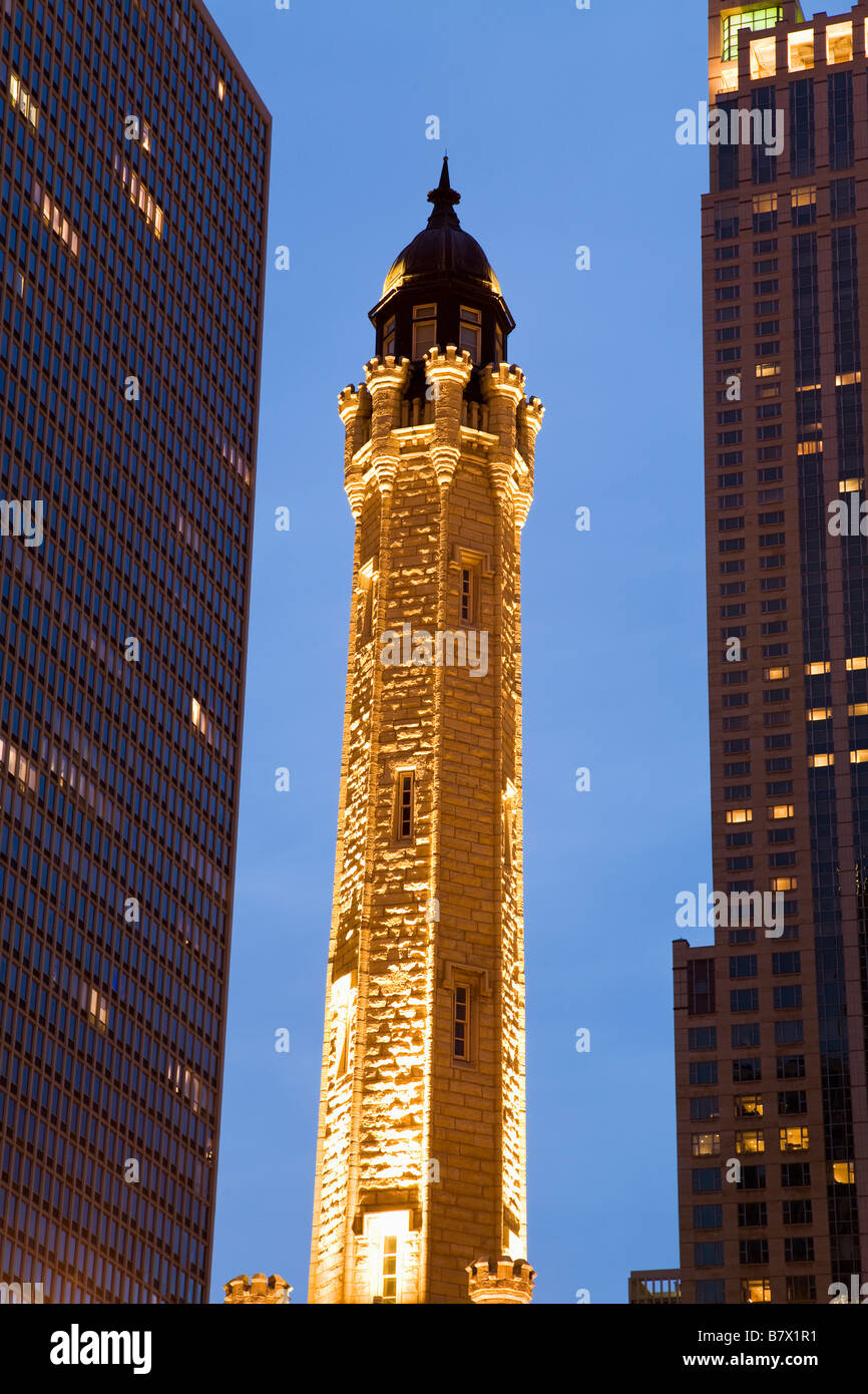 ILLINOIS Chicago Spire of Water Tower building on Michigan Avenue at dusk between two modern high rise buildings Stock Photo