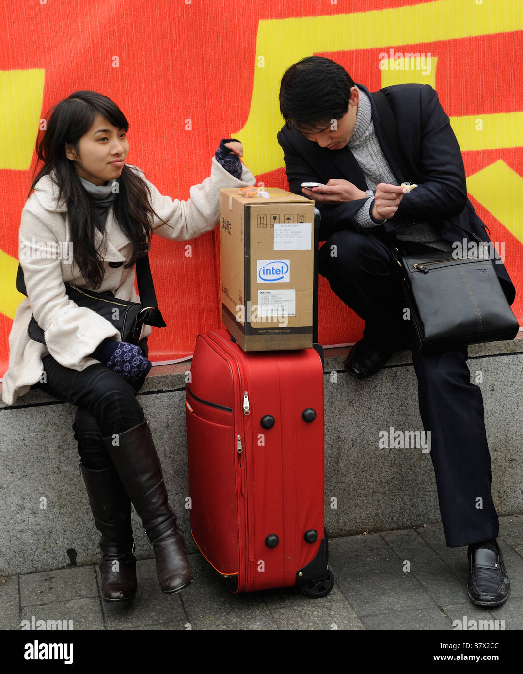 A man checks his mobile phone while waiting to leave the train station of Nanchang, Jiangxi, China. 05-Feb-2009 Stock Photo