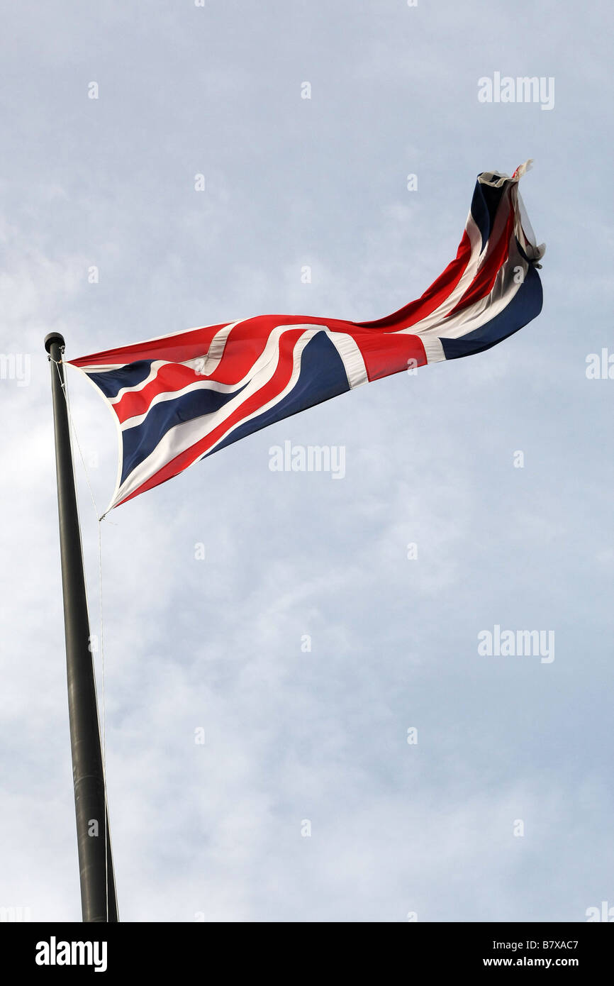 The Union Jack (flag), the flag of the United Kingdom, fully flying against a blue sky with some slight cloud. Stock Photo