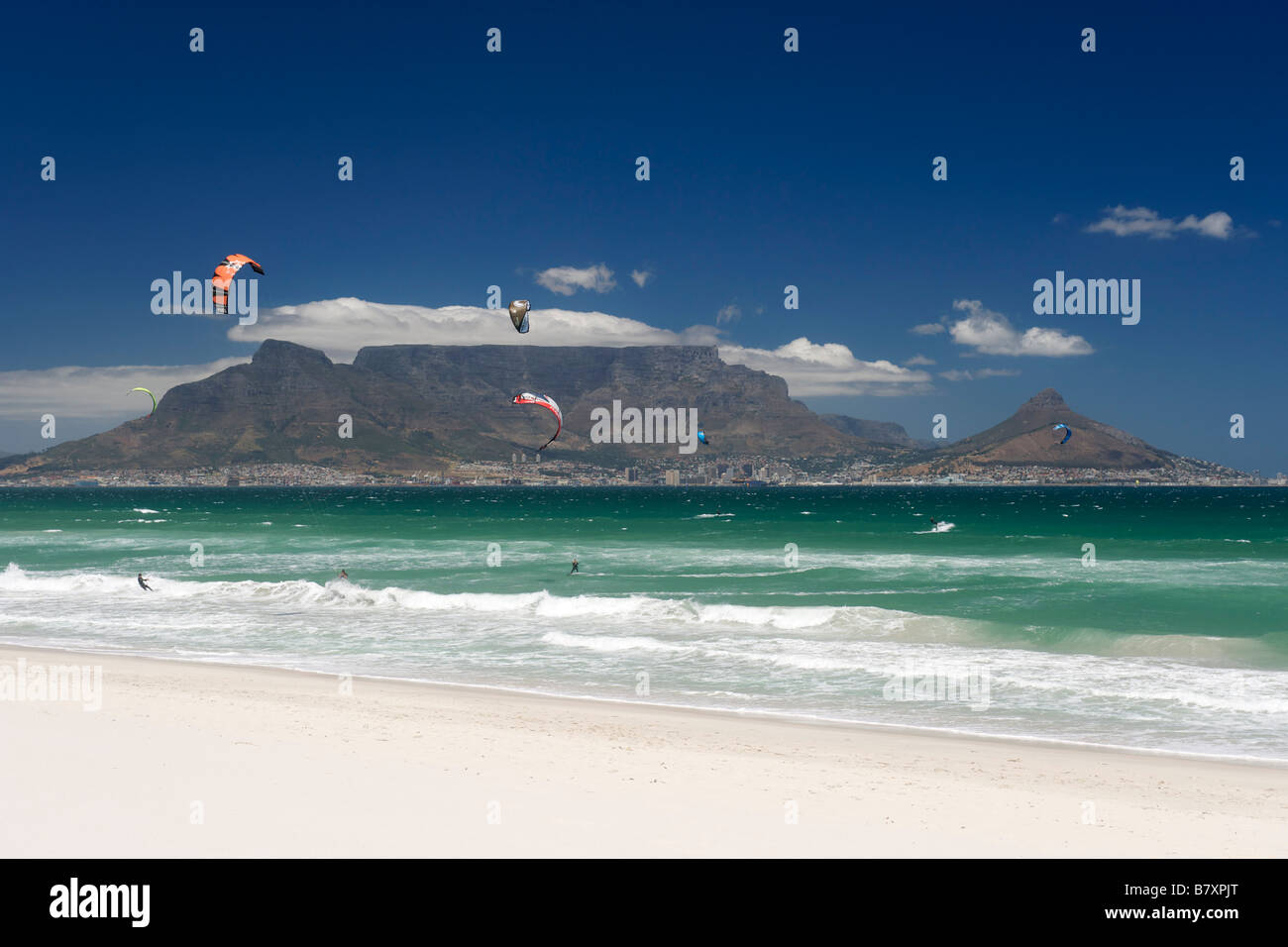 Kite-surfers at Blouberg Beach with a view of Table Mountain and the city of Cape Town visible across Table Bay. Stock Photo
