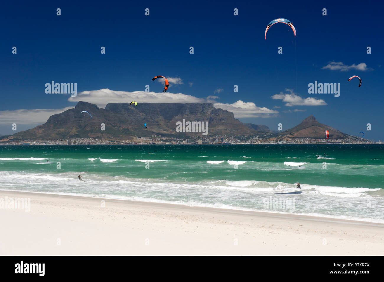 Kite-surfers at Blouberg Beach with a view of Table Mountain and the city of Cape Town visible across Table Bay. Stock Photo