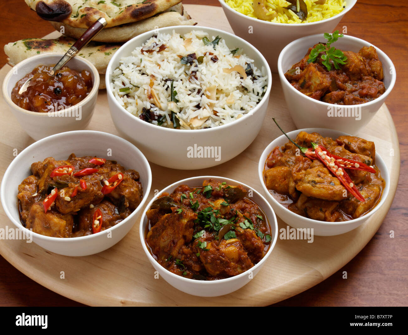 Four chicken curries rice and chutney Stock Photo Alamy