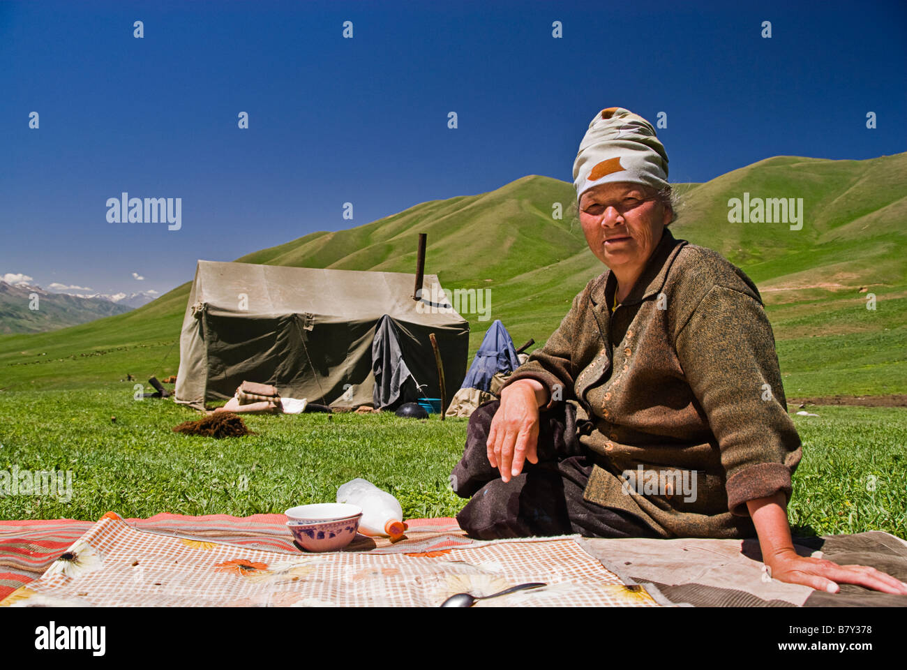Kyrgyz woman outside a tent drinking horse milk Kyrgyzstan Stock Photo