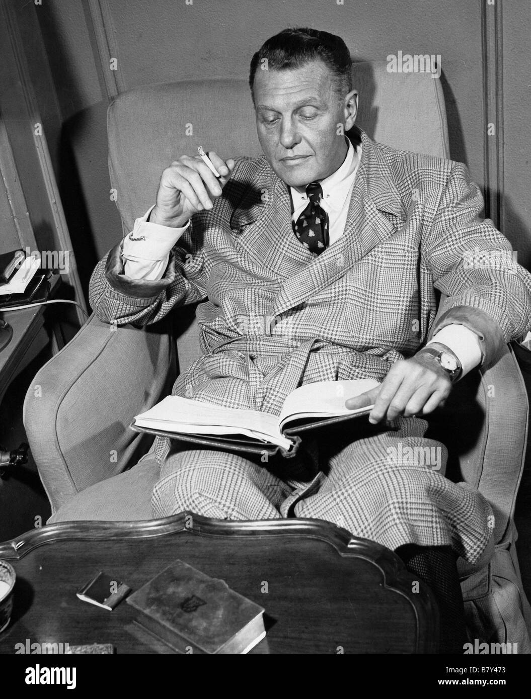 Ralph Bellamy at home on a Sunday, reading a script for his next film. Stock Photo