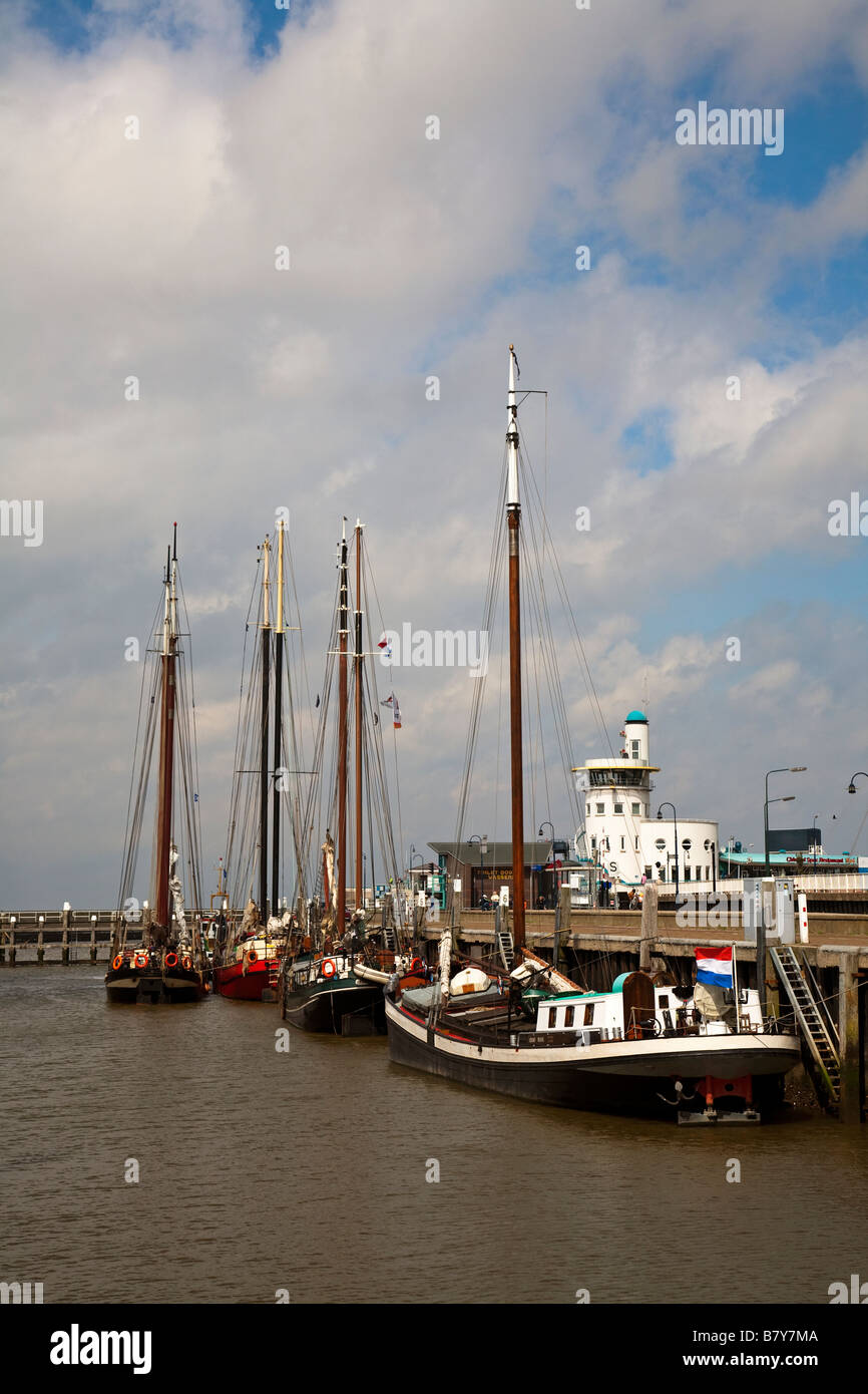 Traditional fishing boats in harbour with lighthouse Harlingen Friesland Netherlands Stock Photo