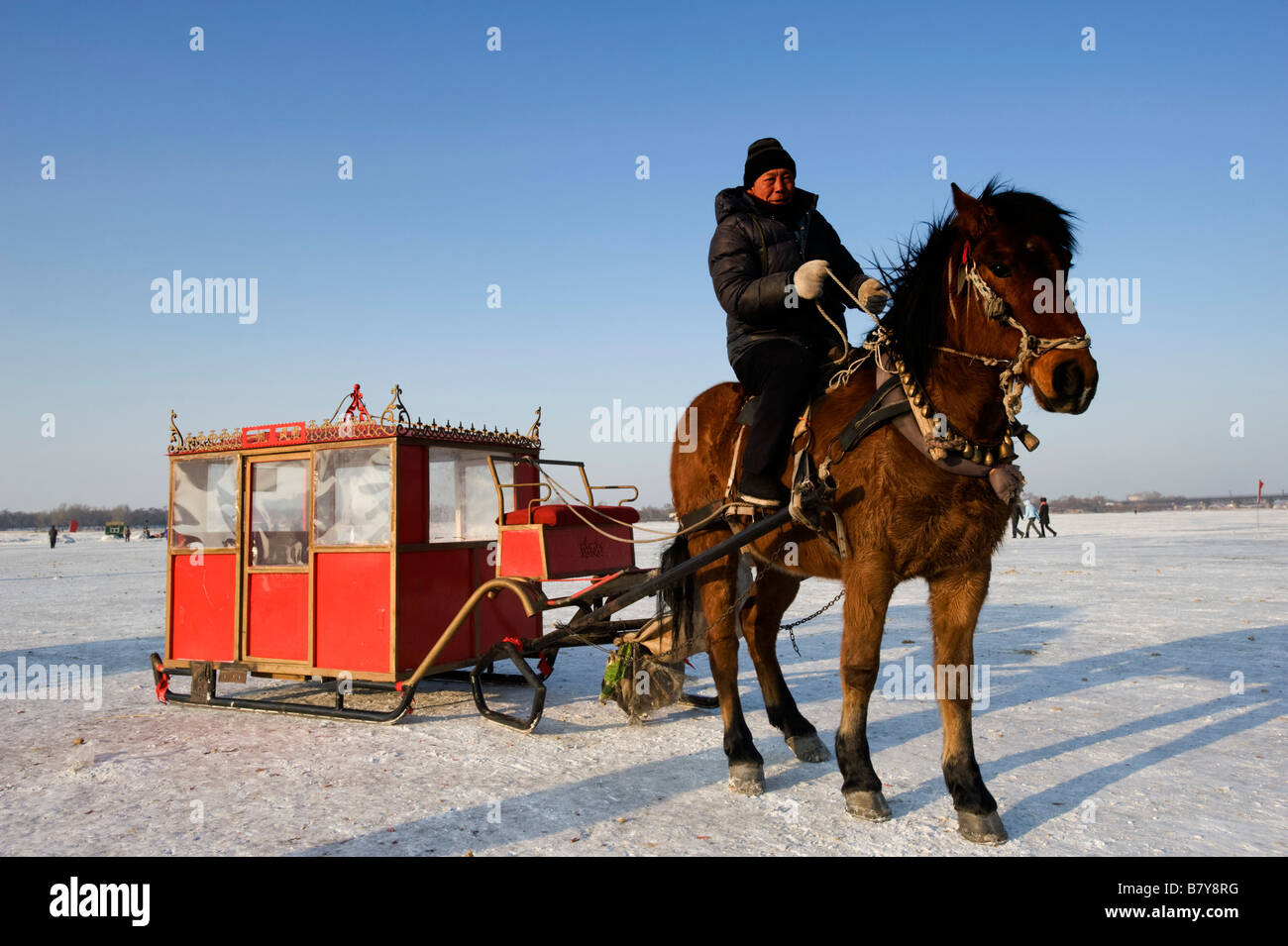 Horse drawn sleigh to carry people and tourists across frozen Songhua River in Harbin northern China during winter 2009 Stock Photo