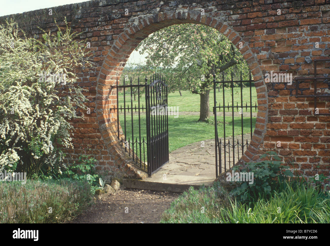 Lullingstone Kent UK ironwork moon gate in brick wall seen in spring