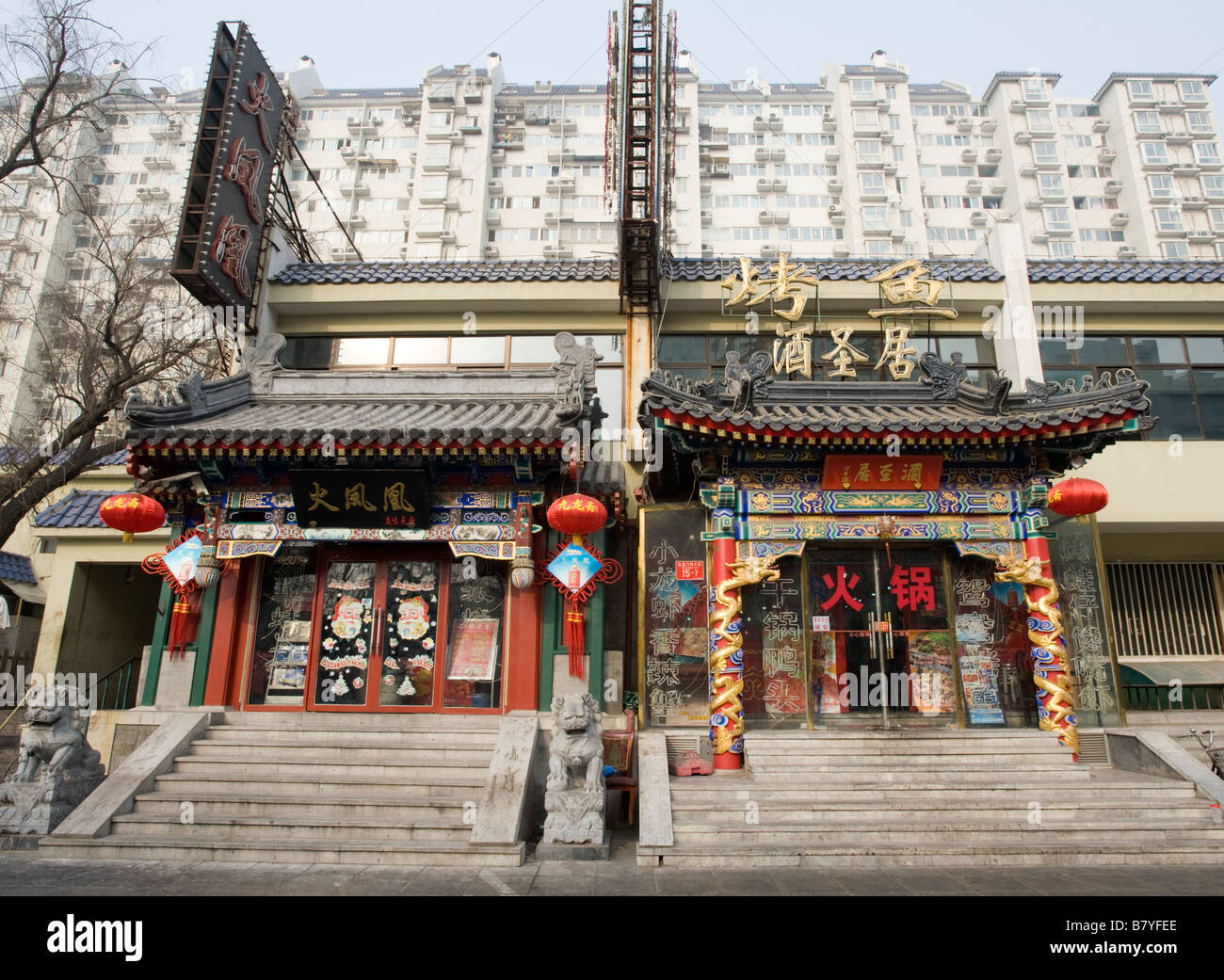 Contrast between traditional ornate old buildings with restaurants and modern apartment buildings to rear in central Beijing Stock Photo