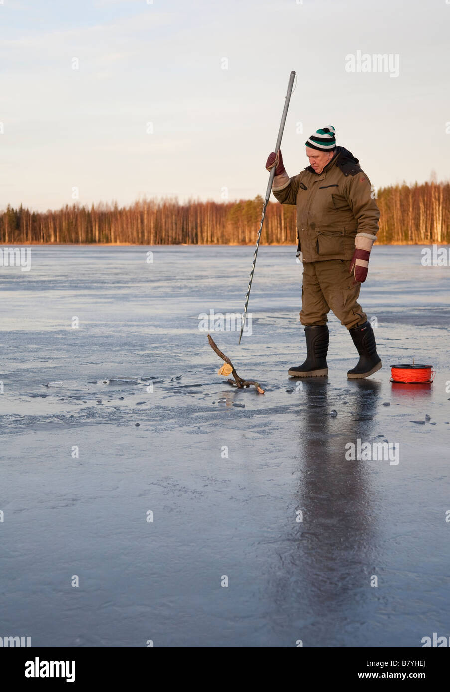 Elderly man using an ice saw to open a hole to ice for checking fishing  nets , Finland Stock Photo - Alamy