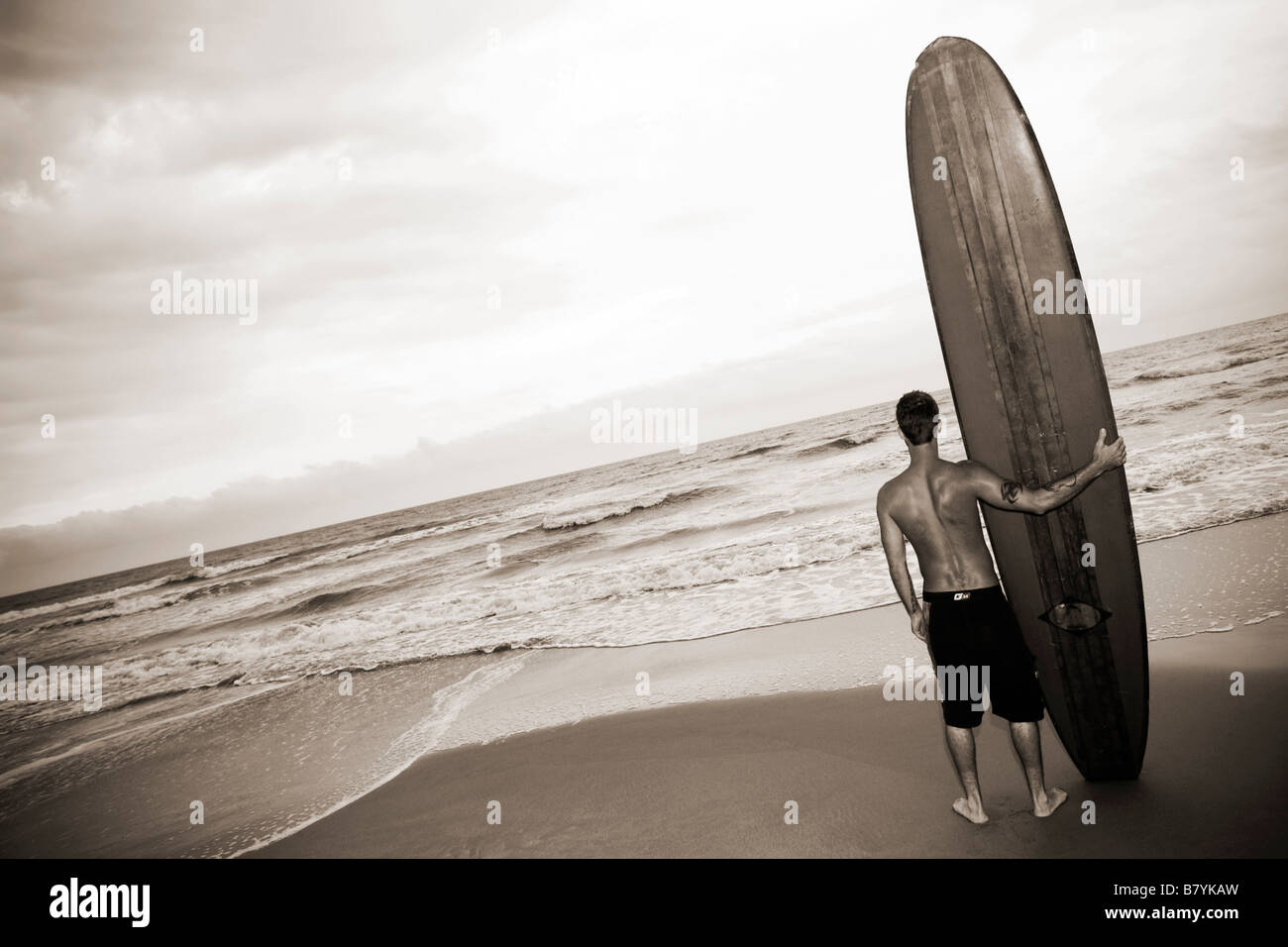 Surfer at beach holding surfboard, portrait Stock Photo - Alamy