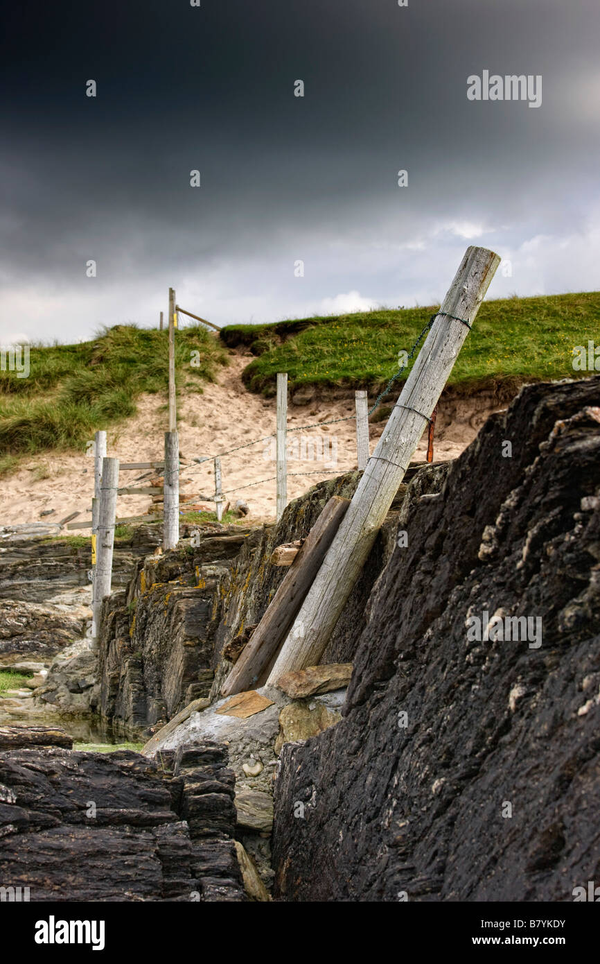Old fence posts on rocky beach Stock Photo Alamy