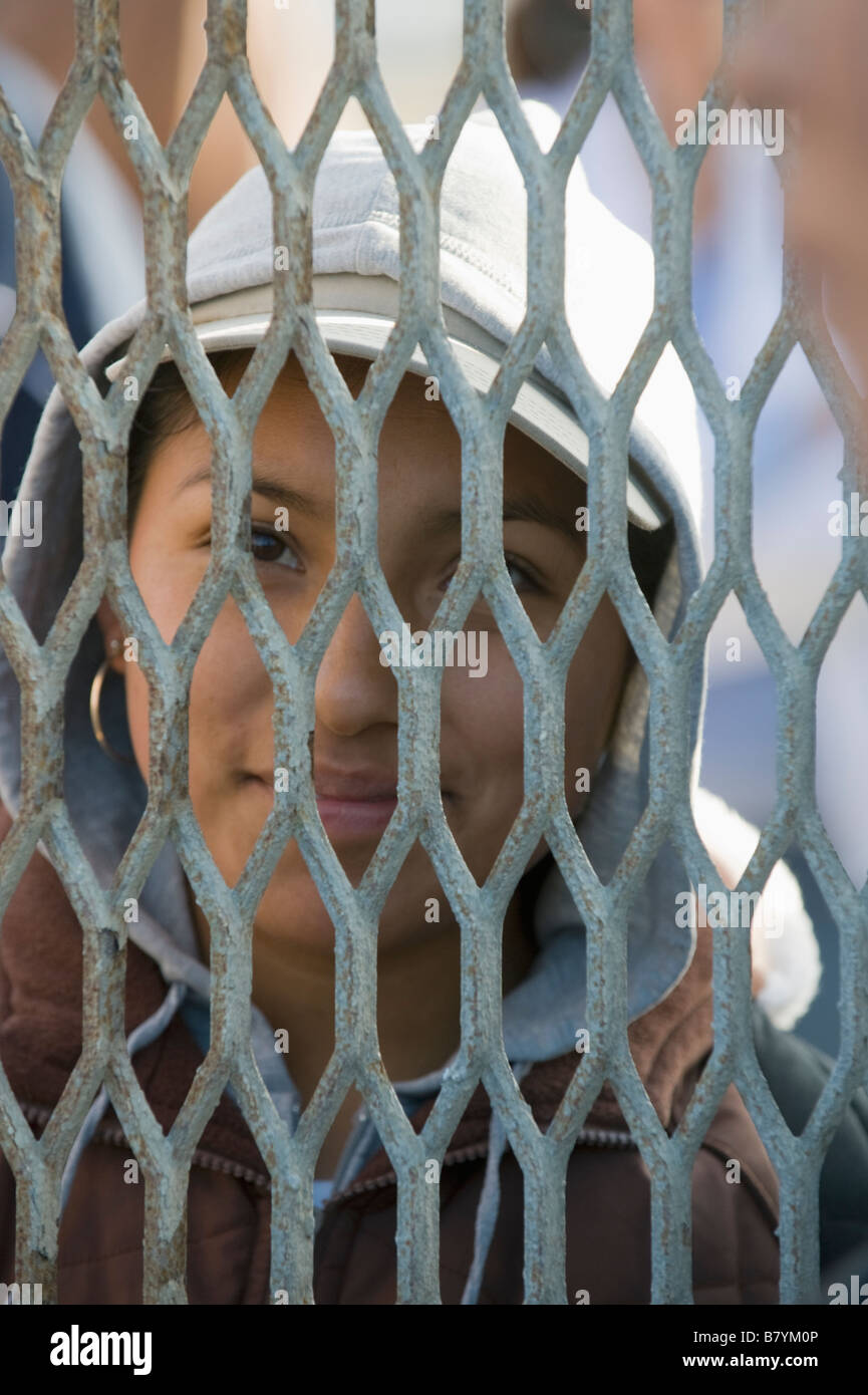 Mexican woman through US-Mexico Border fence, Tijuana Mexico Stock Photo