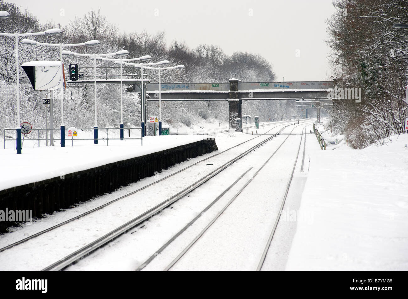A snow covered railway line and station platform Stock Photo