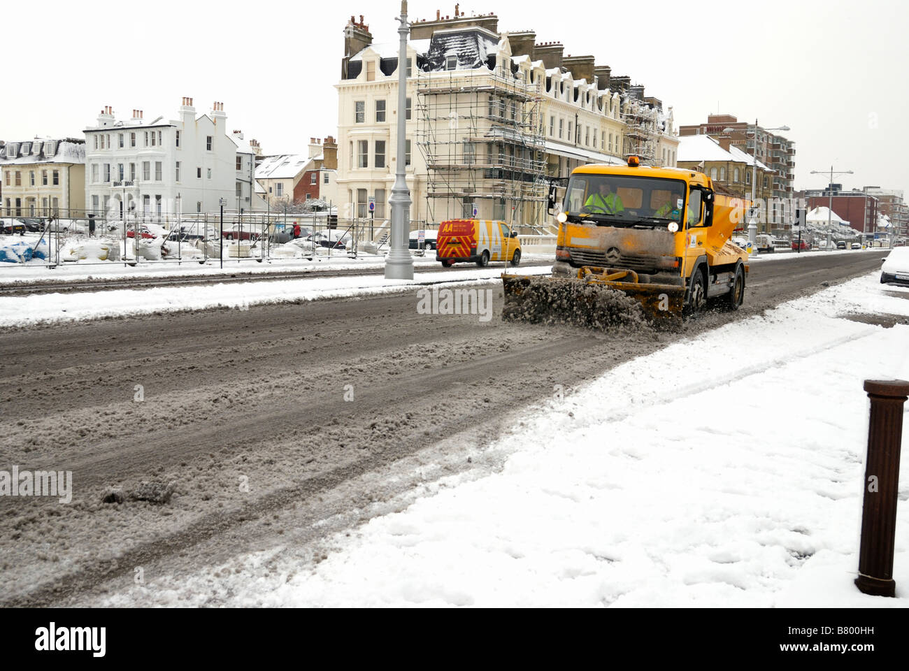 Snow plough and gritter clearing road Stock Photo