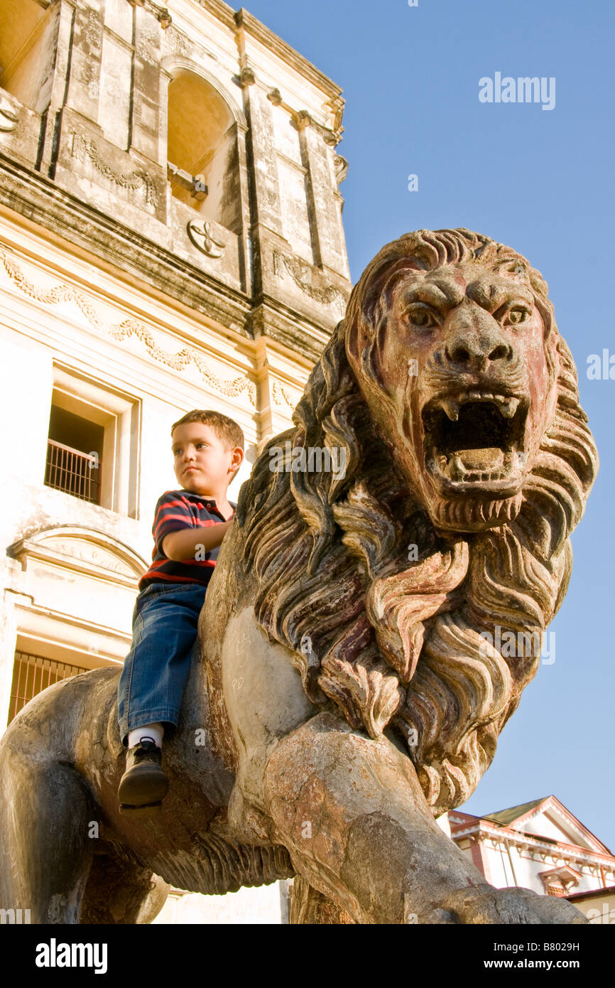 Leon Cathedral, Spanish colonial architecture, with Nicaraguan boy on lion statue flanking entrance Stock Photo
