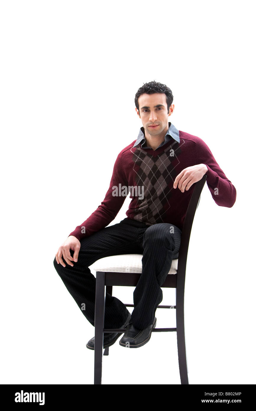 Handsome guy wearing business casual clothes sitting on a high chair isolated Stock Photo