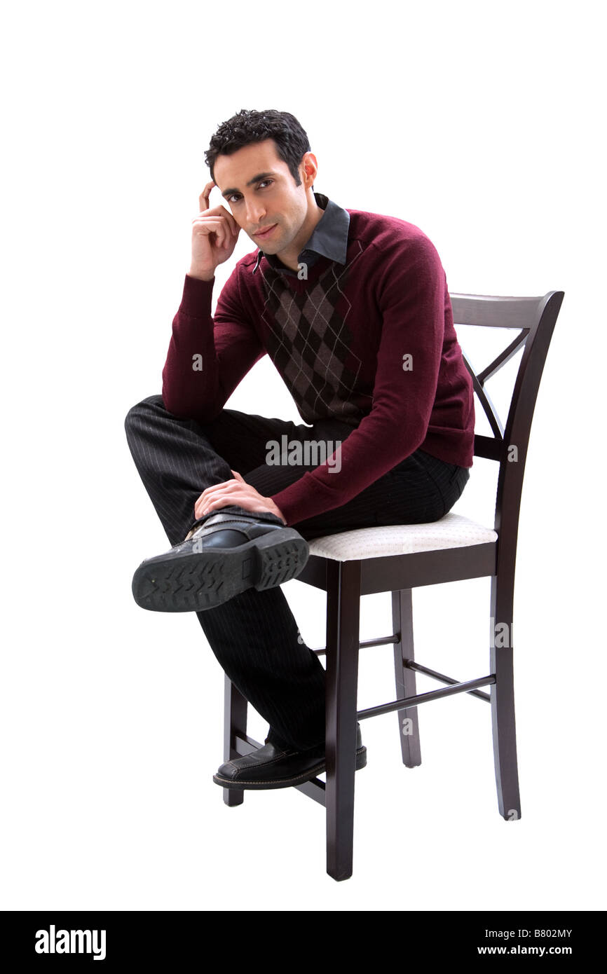 Handsome guy wearing business casual clothes sitting on a high chair and thinking isolated Stock Photo