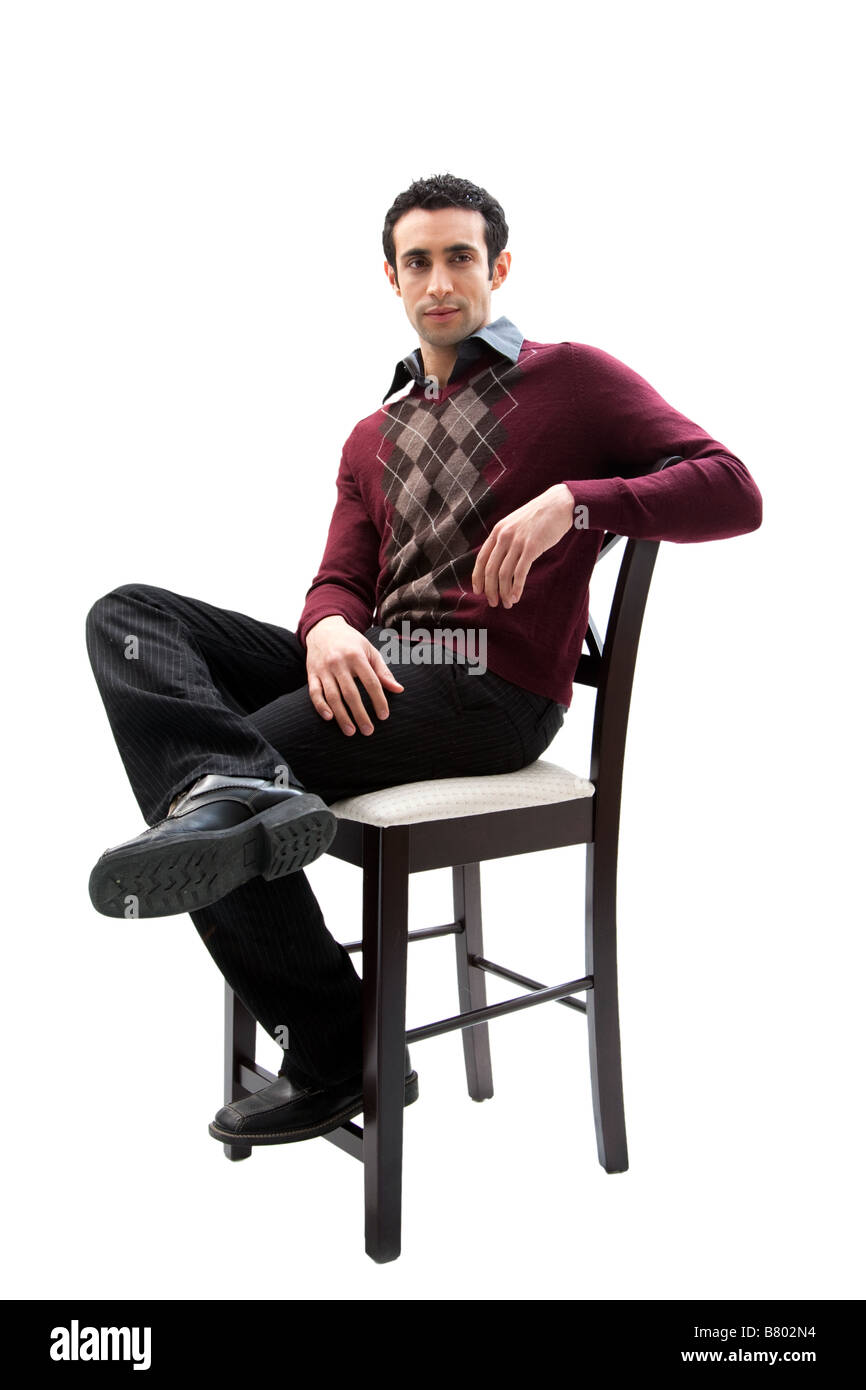 Handsome guy wearing business casual clothes sitting on a high chair with legs crossed and arm resting isolated Stock Photo