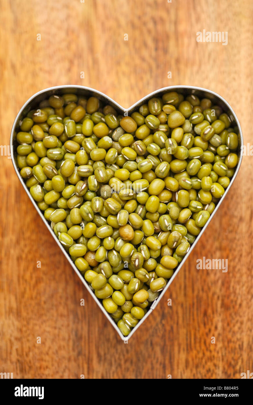 Mung beans held inside a heart shape. Stock Photo