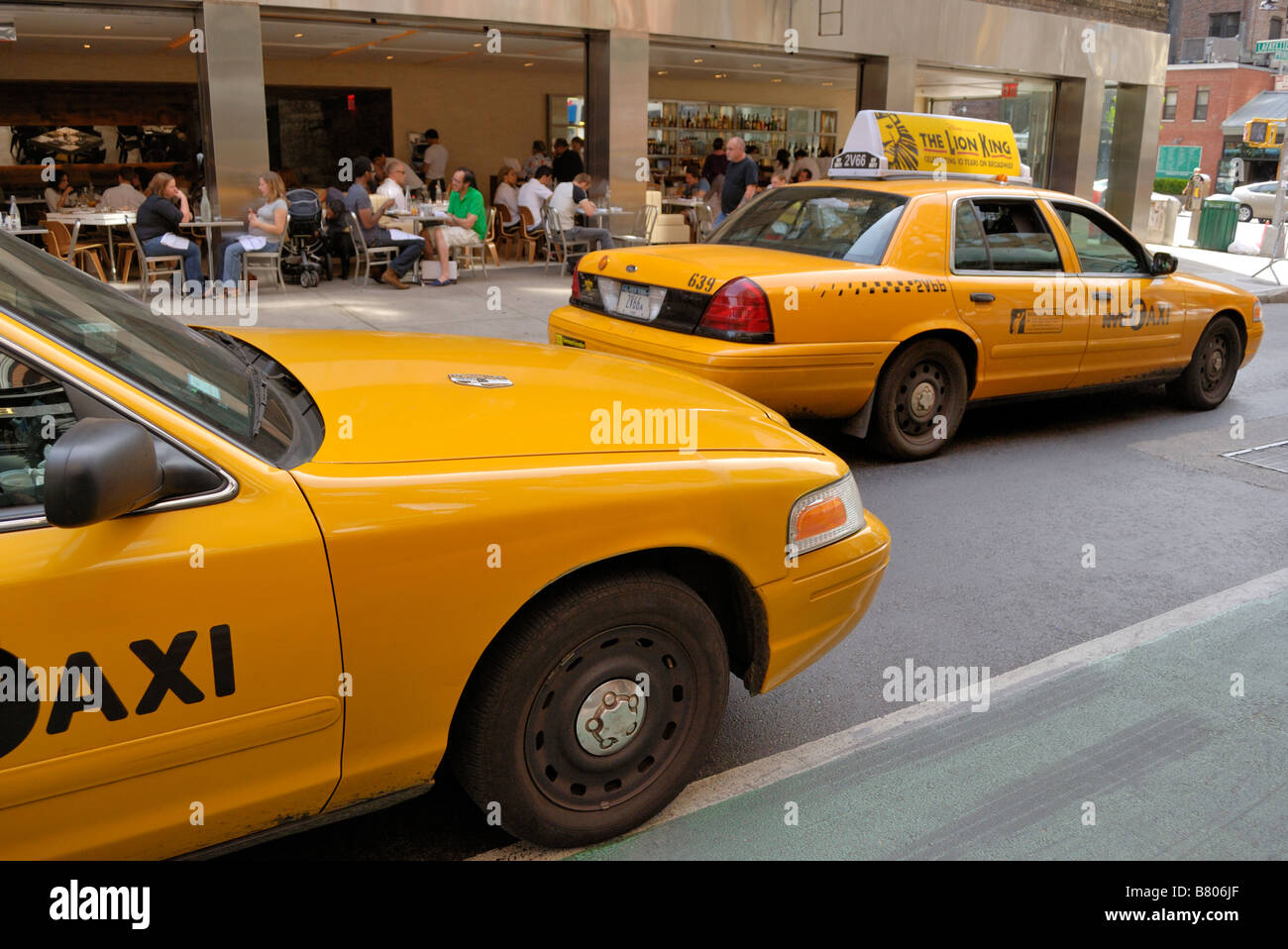 Taxi cabs passing alfresco dinners in SoHo in New York City. Stock Photo