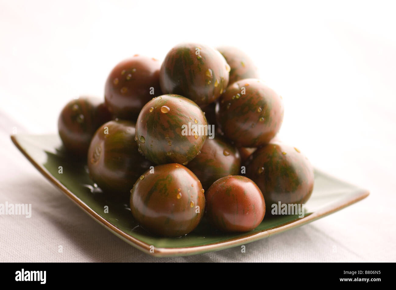 A batch of green tomatoes piled in a pyramid Stock Photo - Alamy