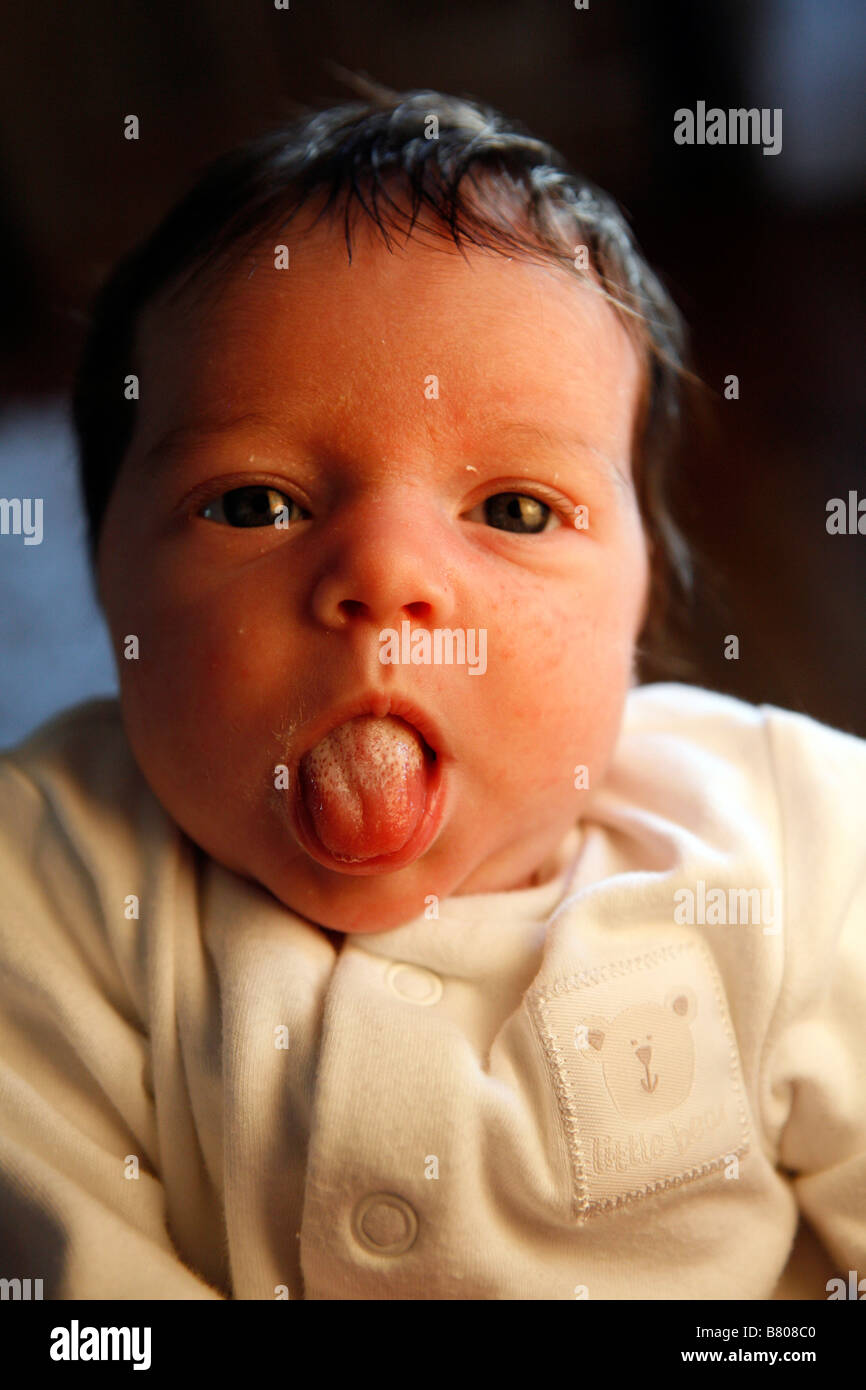 A baby girl sticks her milky tongue out . Stock Photo