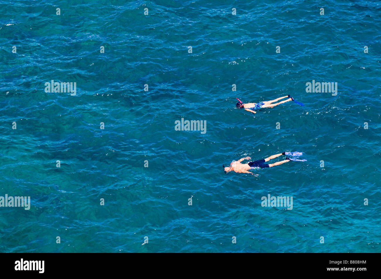 Snorkelers in the blue Pacific waters at Hideaways Beach Princeville