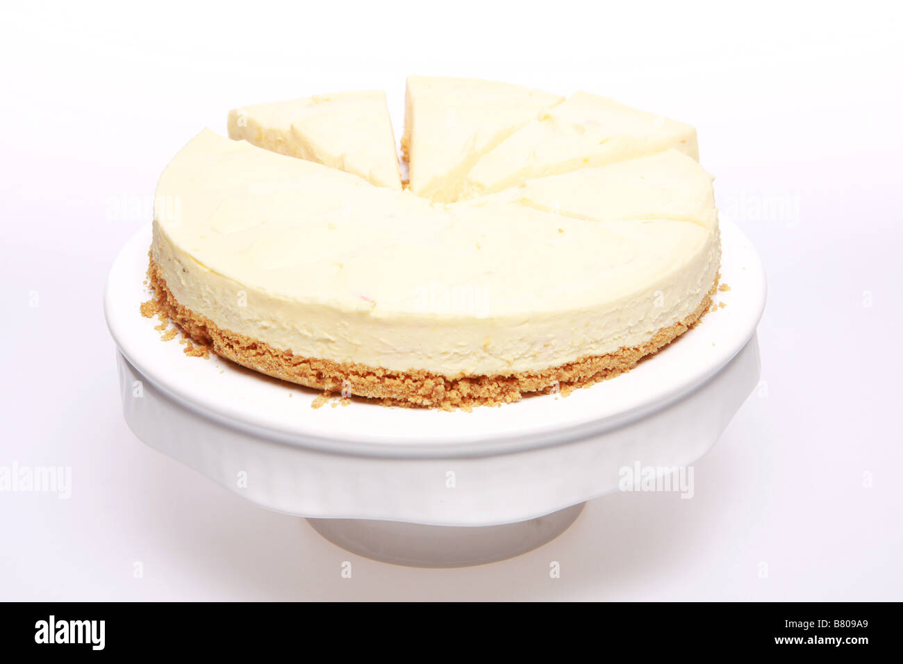 Sliced cheesecake on a cake dish isolated on white Stock Photo Alamy