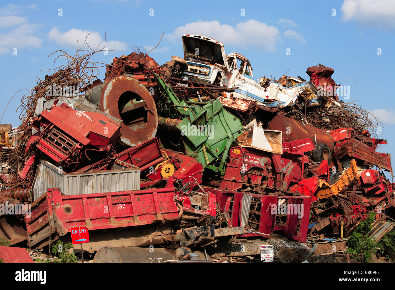 A massive pile of wrecked vehicles and machinery in a junkyard Stock