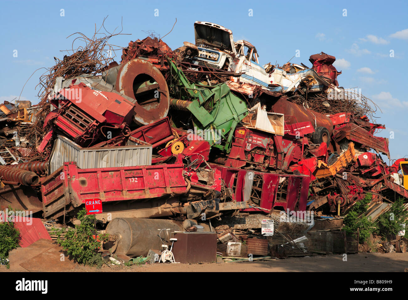 A massive pile of wrecked vehicles and machinery in a junkyard Stock