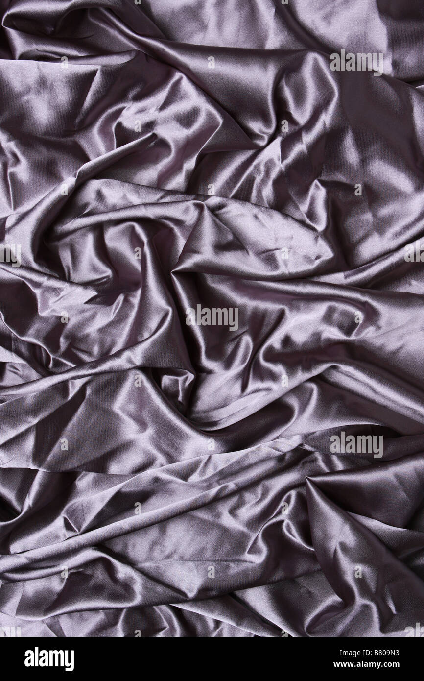 silver colored satin shot from above with creases and folds creating ...