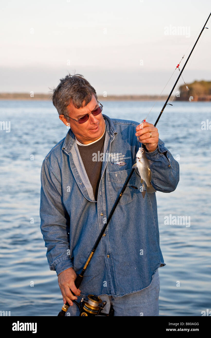 Man looking a small fish caught fishing at Crooked River State Park in St.  Marys Georgia, USA Stock Photo - Alamy