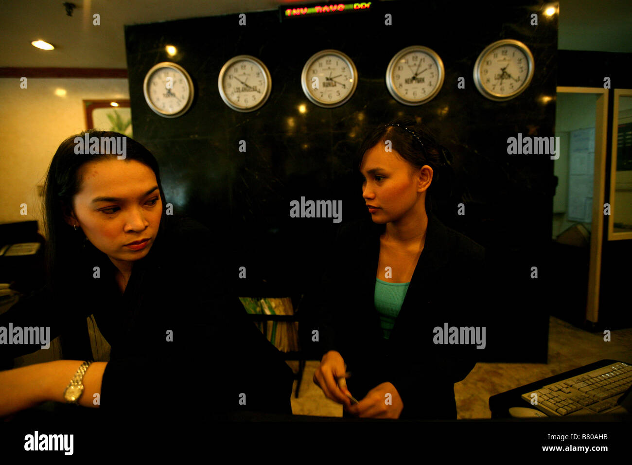 PHILIPPINES Manila Two hotel receptionists behind the reception desk at