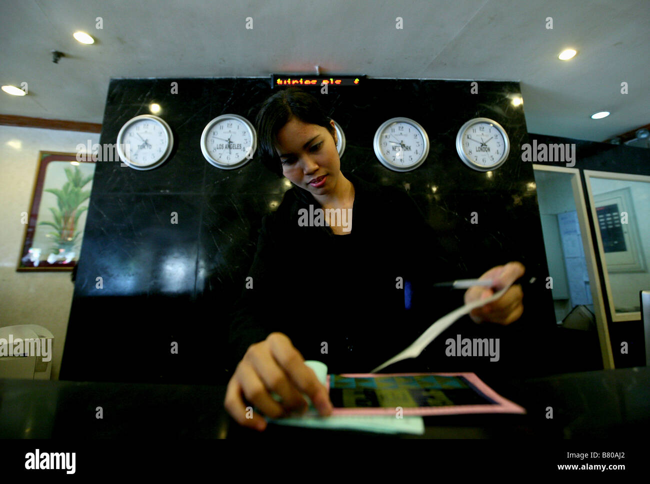 PHILIPPINES Manila Hotel receptionist behind the reception desk at a
