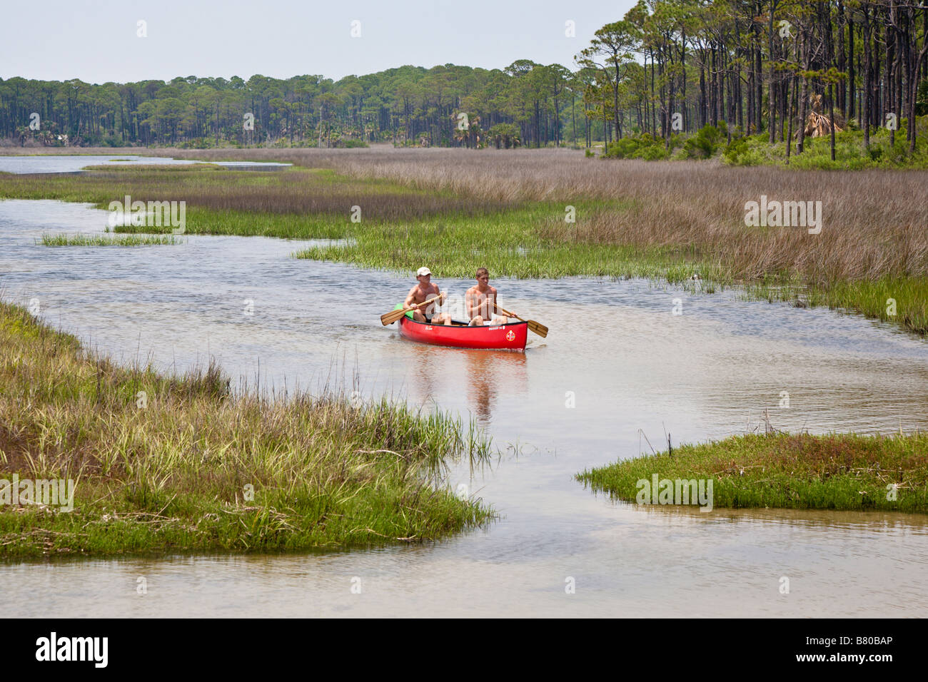 Two men paddling red canoe in wetlands area of St Joseph Peninsula