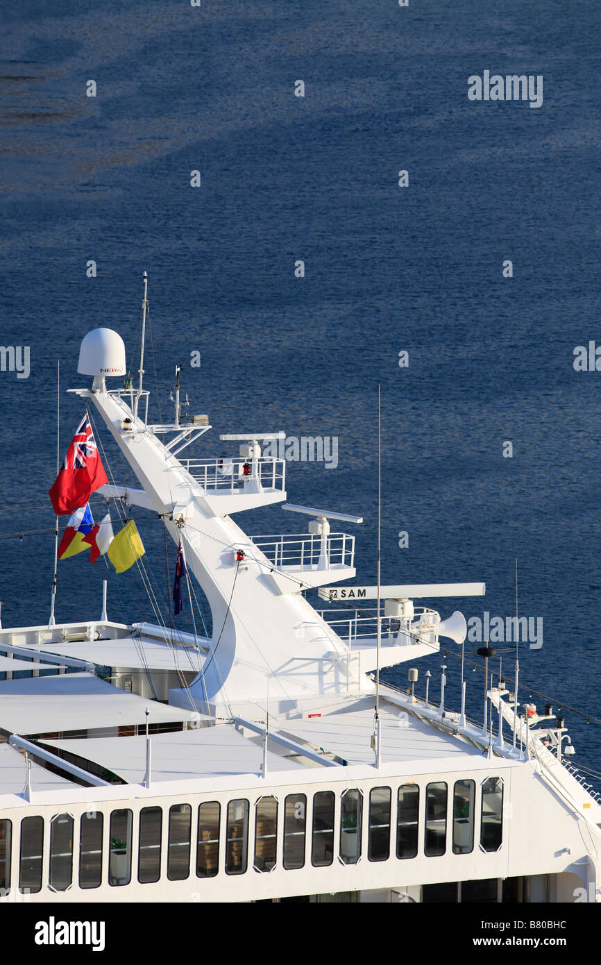 Pacific Sun cruise ship's radar tower with three radars and flying P&O flag and red Ensign with a blue sea background Stock Photo