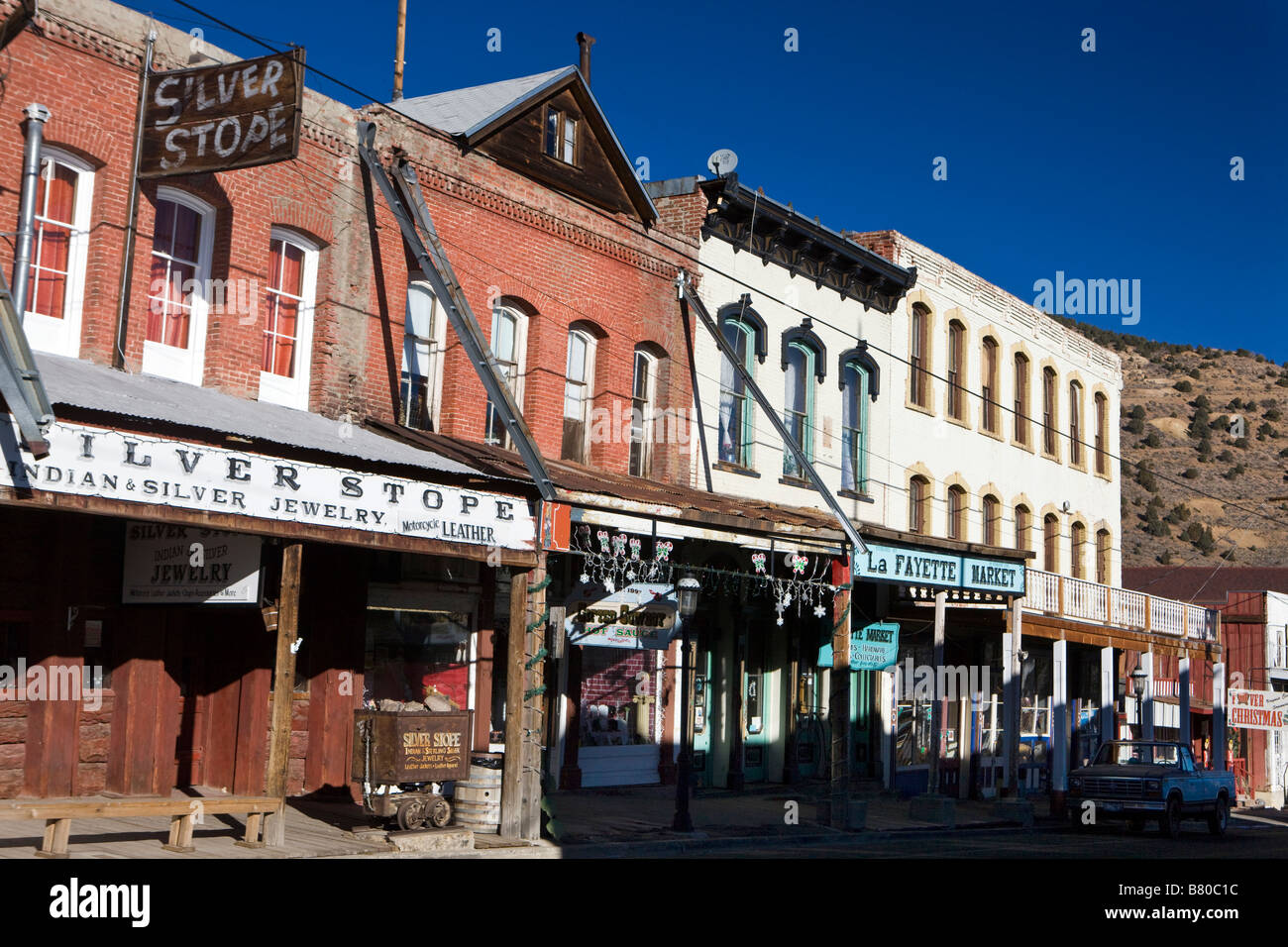 Shops with hanging signs and a wooden boardwalk side walk line Main