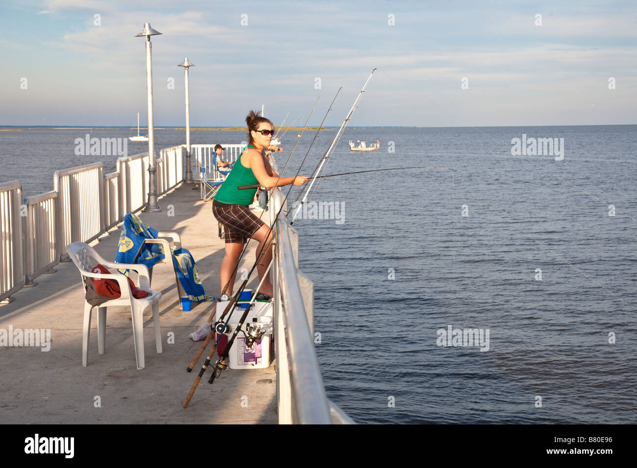 Young woman fishing from pier in Gulf of Mexico at Cedar Key, Florida