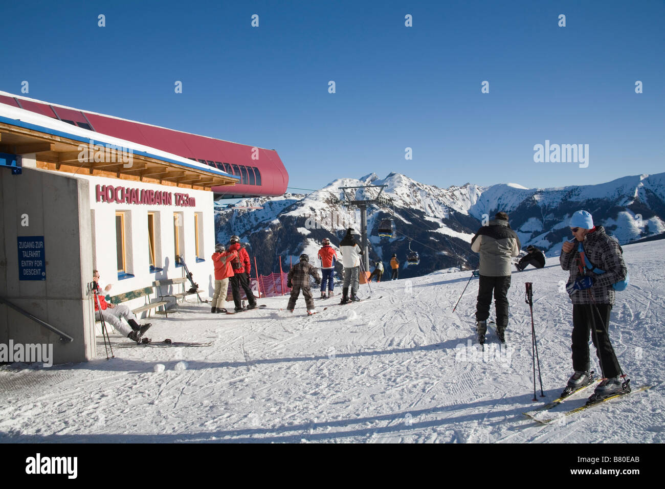 Rauris Austria EU January Skiers at the Hochalmbahn gondola station preparing to descend the ski slopes man lighting a cigarette Stock Photo