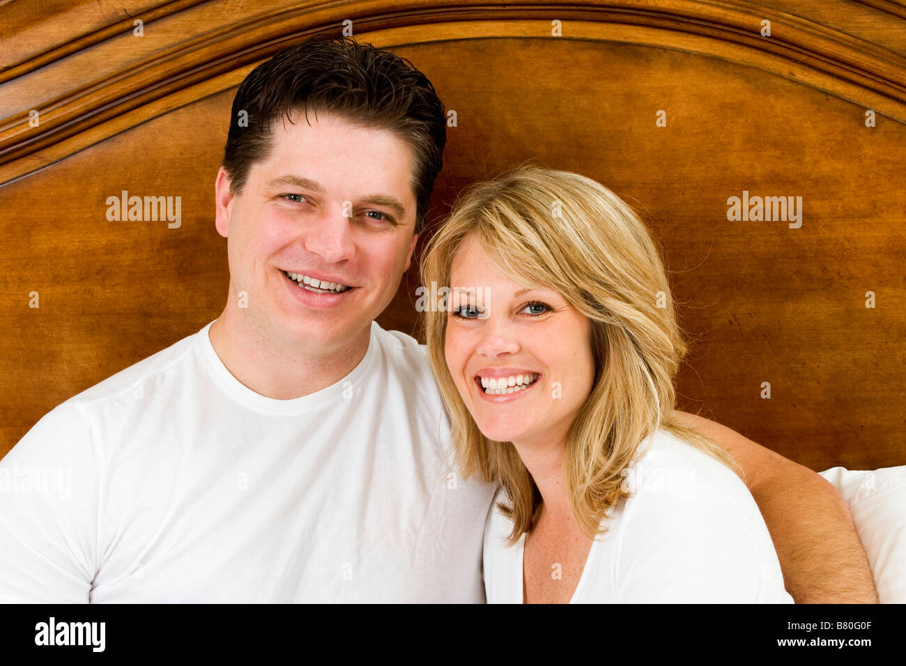 couple lying in bed smiling togetherness Stock Photo