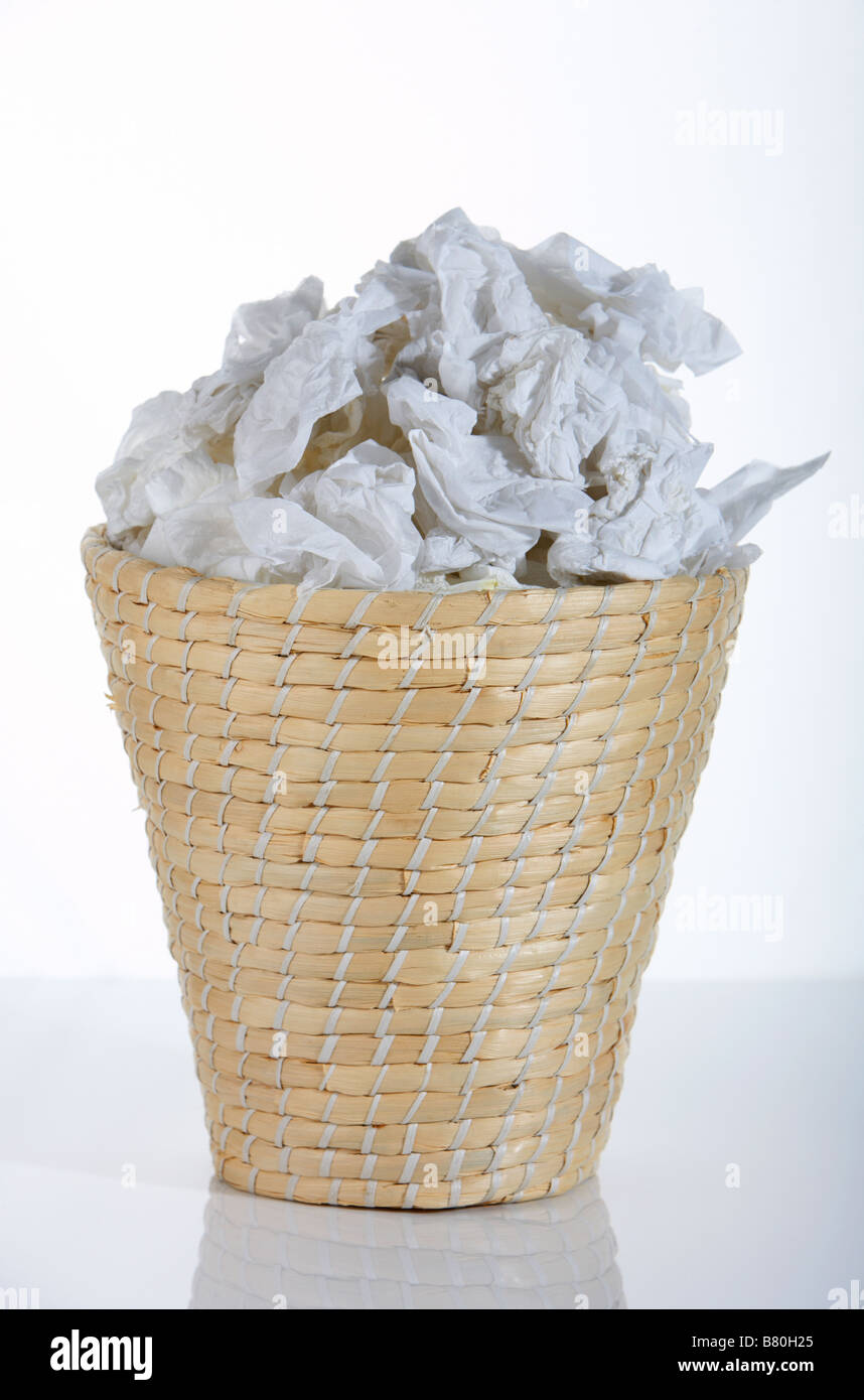 wicker waste paper basket bin full of used tissues Stock Photo