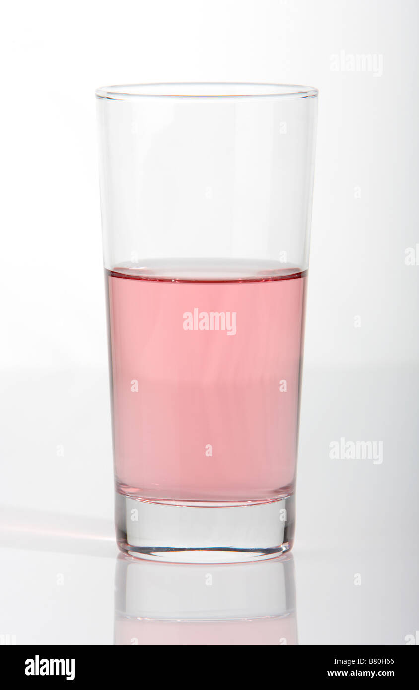 glass half empty half full of diluted purple fruit juice on a white background Stock Photo