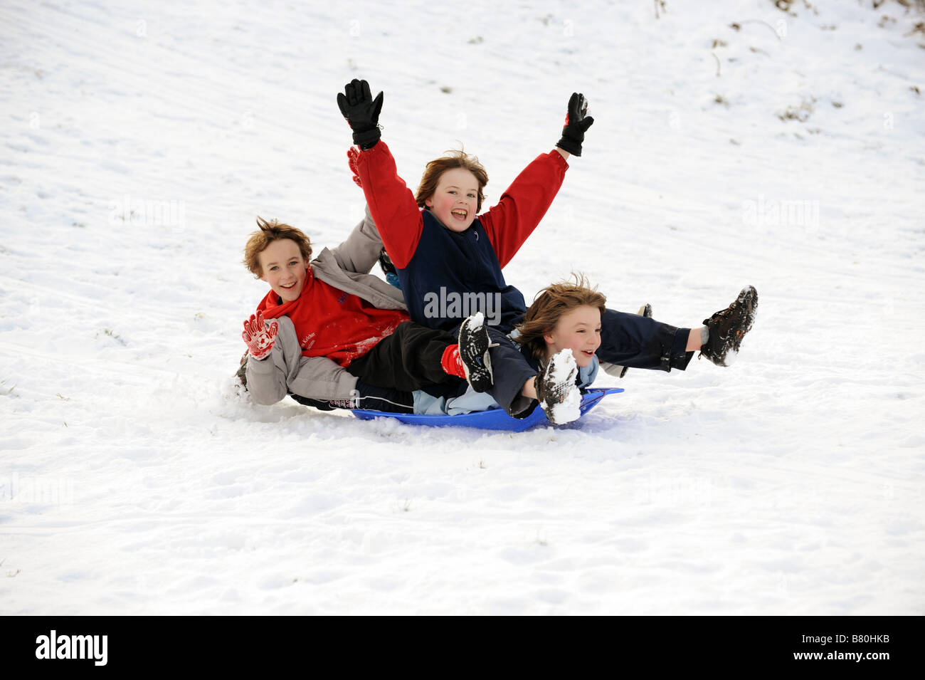 Three young boys sledging in the snow winter 2009 playing fun PICTURE BY DAVID BAGNALL Stock Photo