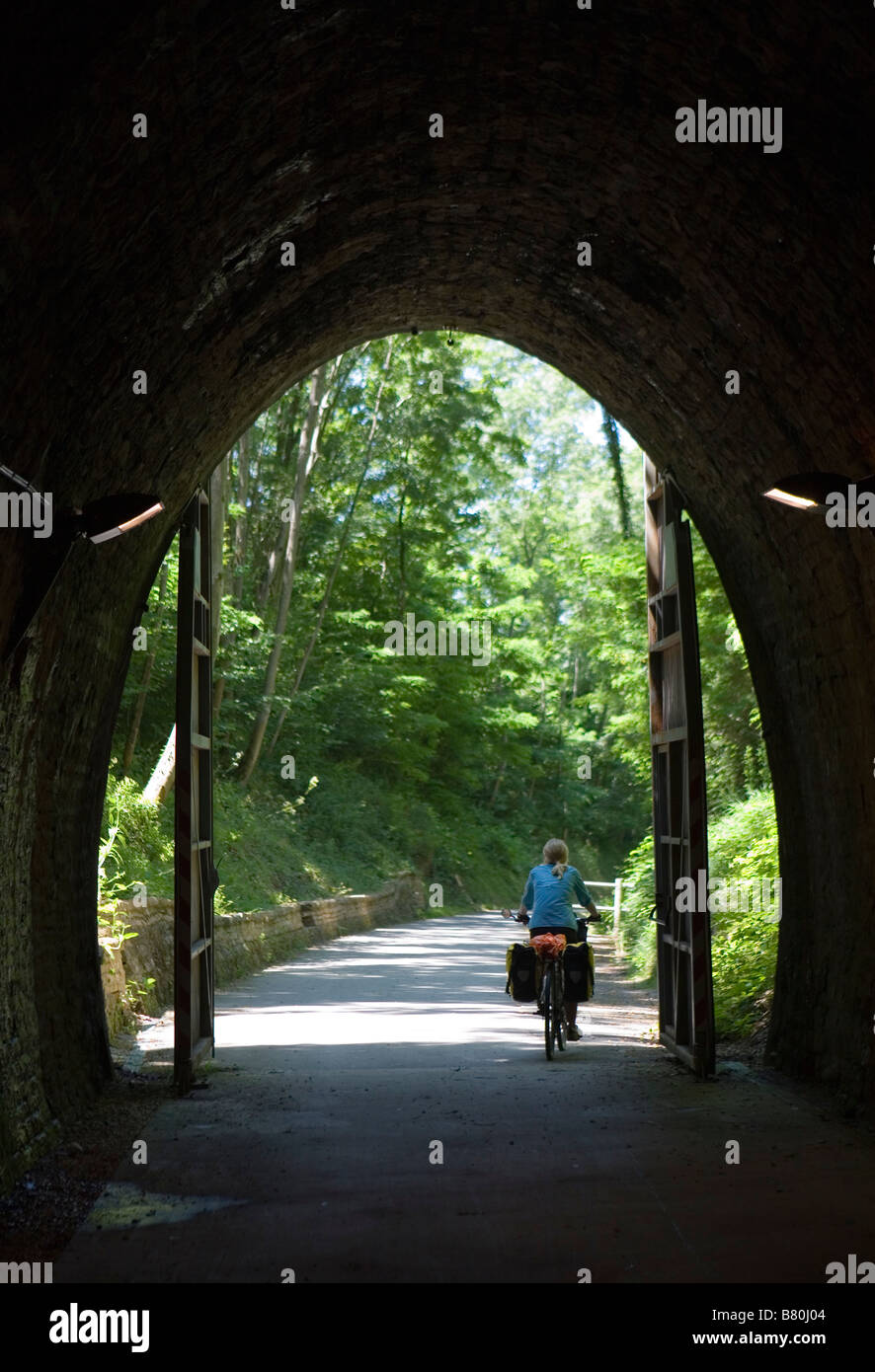 Cyclist exiting the rail tunnel on the Voie Verte cycling trail in Burgundy Stock Photo